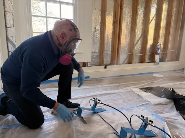 A restoration technician setting drying equipment in an Huntington Beach home stripped to the studs