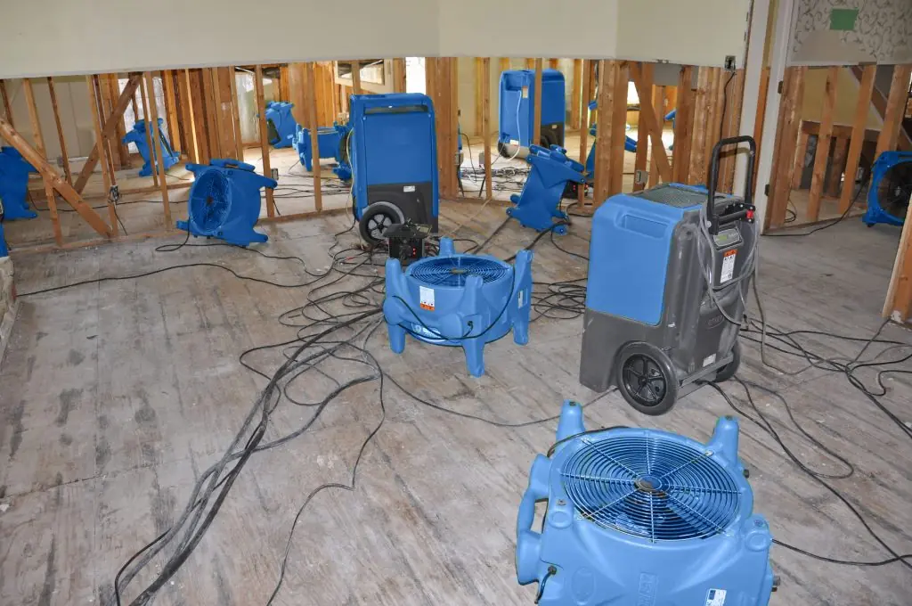Air movers drying a gutted Huntington Beach room after major water damage